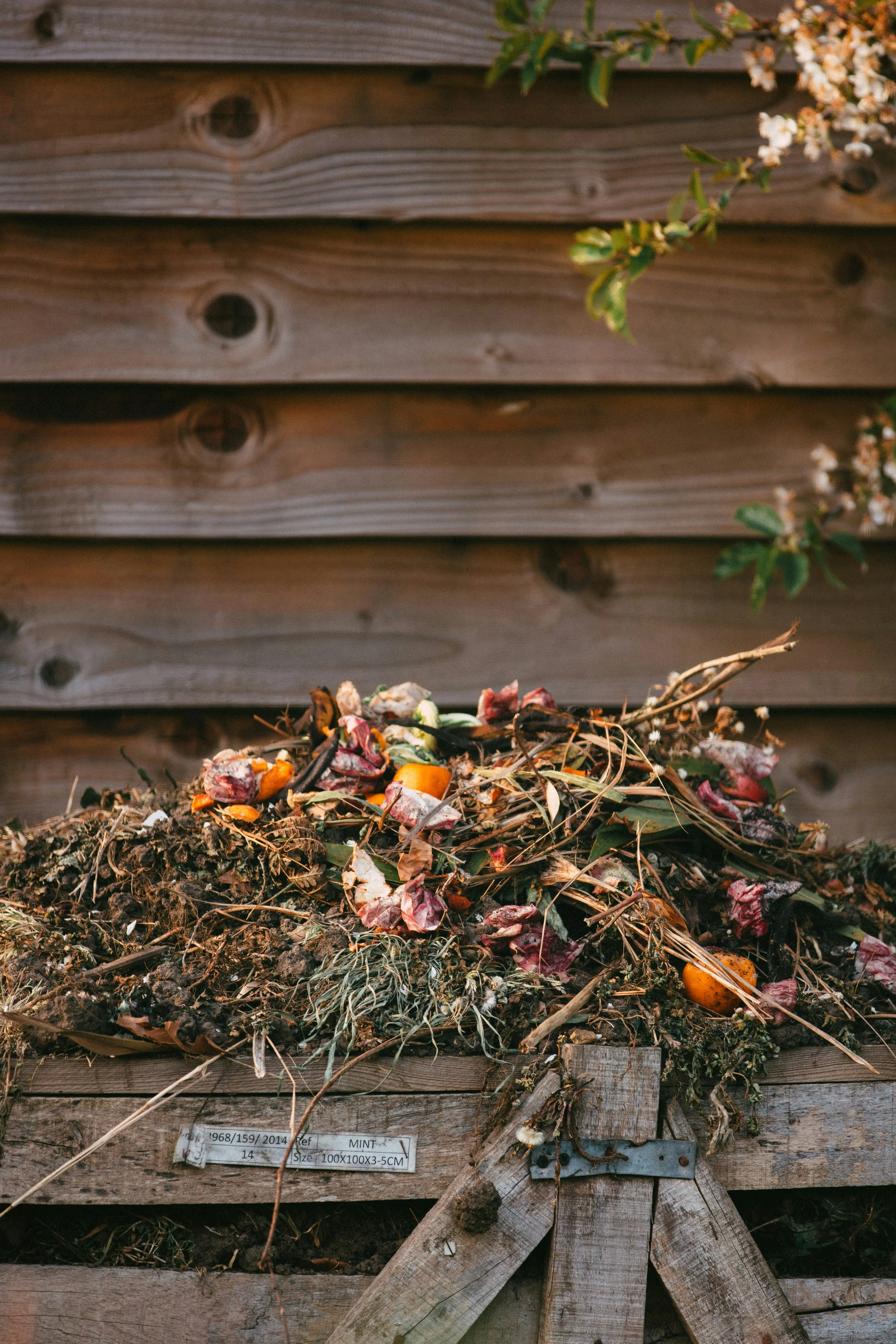 A garden compost heap with a mix of kitchen and garden waste breaking down into rich dark compost